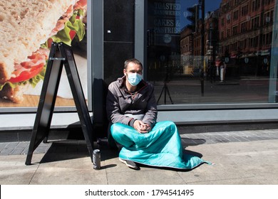 Manchester, United Kingdom - 12th Aug 2020: Homeless Male Begging On The Street Wearing A Face Mask Because Of The Covid 19 Pandemic