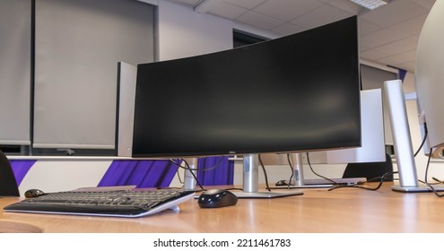 Manchester, United Kingdom - 17th Sept 2022: Empty Office Work Station With A Wide Screen Monitor And Keyboard.