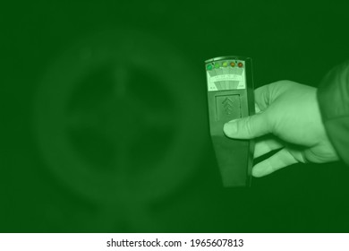 Manchester, United Kingdom - 22nd April 2021: Paranormal Investigator Holding A K2 Meter In A Graveyard In Night Vision Green.