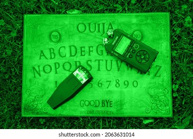 Manchester, United Kingdom - 25th Oct 2021: Ouija Board And Ghost Hunting Equipment In Night Vision Green.