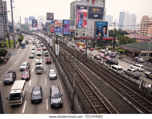 MANDALUYONG CITY, PHILIPPINES - AUGUST 18,\
2017: Private and public vehicles passing along EDSA and the Boni\
MRT Station in Mandaluyong City,\
Philippines.