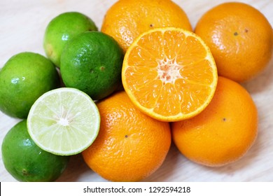 Mandarin Oranges And Limes On Wooden Board.