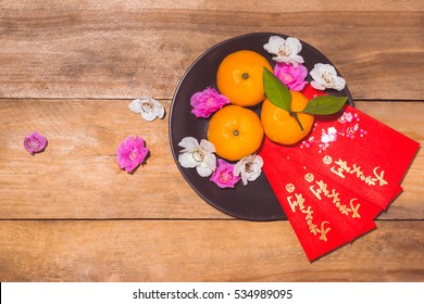 Mandarin oranges and Lunar New Year with text "Happy New Year" on red pocket. Tet Holiday concept.
