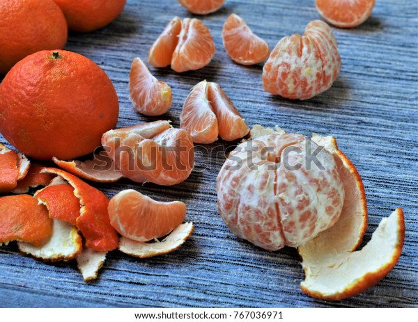Mandarin oranges peeled and divided into
slices, fresh fruit, citrus aroma, slices of mandarin on the grey
fabric tablecloth.