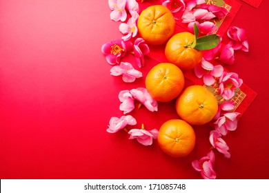 Mandarins with Red Packets and Plum flowers on red background 