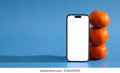 mandarins in vertical stack beside smartphone, simulating quick grocery order placement via delivery app