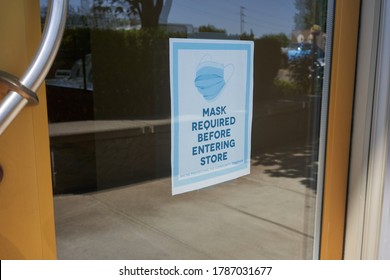 Mandatory Mask Policy Signage At The Entrance To A Retail Store During The Coronavirus Pandemic.