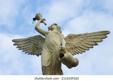 Mandiri Land, Jember, Indonesia - January 23, 2022: Beautifully carved angel statue photographed from below facing the sky where the weather is very favorable for the beauty of the photo