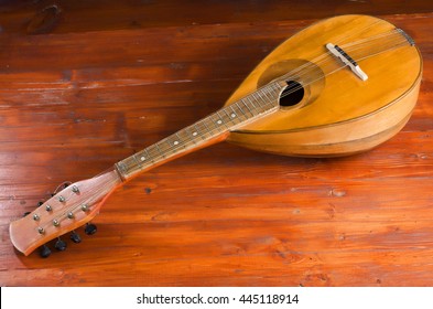Mandolin on the background of painted wood, old musical instrument. 