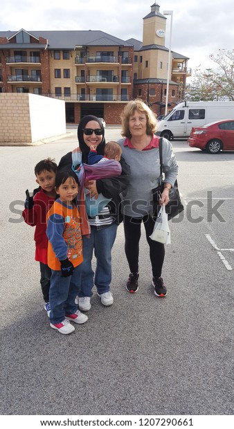 Mandurah, Australia - September 3,2017:\
Asian family with the local people at the car\
park.