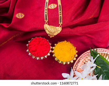 Mangalsutra or Golden Necklace to wear by a married hindu women, arranged with traditional saree with haldi, kumkum and flowers on plate. - Shutterstock ID 1160872771