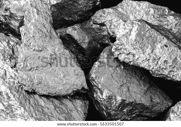 Manganese, manganese,\
or magnesium stone is a chemical element, it is in the manufacture\
of metal alloys. Silver colored ore, industrial use. Ore on black\
isolated background.