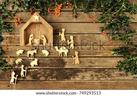 manger scene on rustic wood christmas background with greenery