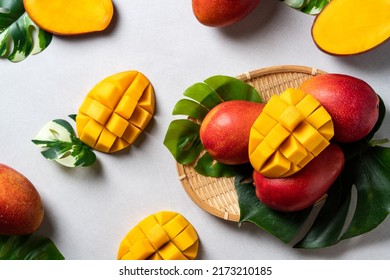 Mango Background Design Concept. Top View Of Diced Fresh Mango Fruit Pattern With Leaves On Gray Table.