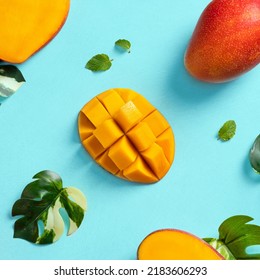 Mango Background Design Concept. Top View Of Diced Fresh Mango Fruit Pattern With Leaves On Blue Table.