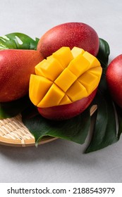 Mango Background Design Concept. Top View Of Diced Fresh Mango Fruit Pattern With Leaves On White Table.