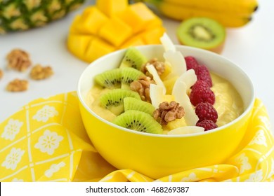 Mango Banana Pineapple Smoothie Bowl Topped With Raspberry, Kiwi, Walnut And Coconut Chips