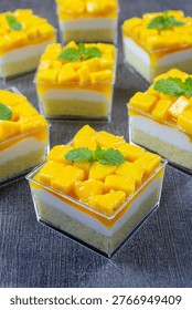 mango dessert box with layers of sponge cake, cream, and fresh mango chunks
