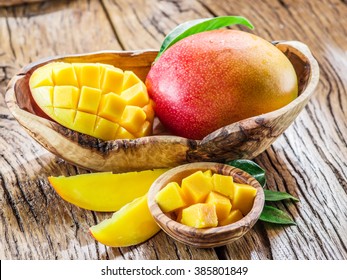 Mango fruit and mango cubes on the wooden table. - Shutterstock ID 385801849