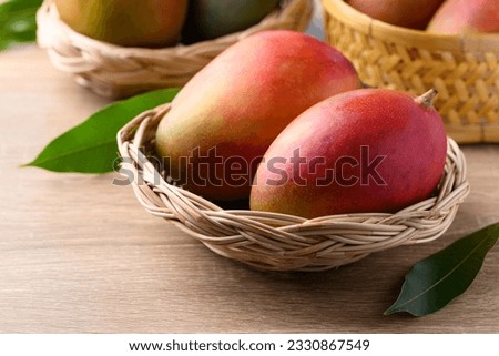 Mango fruit (Palmer mango) in basket on wooden background, Tropical fruit