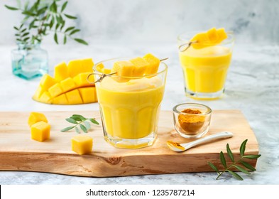 Mango Lassi, yogurt or smoothie with turmeric. Healthy probiotic Indian cold summer drink 
