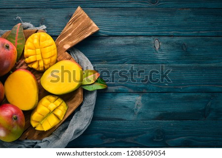Mango. On a blue wooden background. Top view. Free copy space.