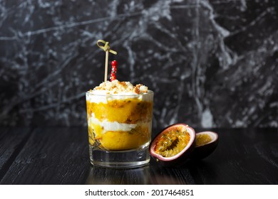 Mango And Passion Fruit Trifle With Cream Cheese And Home Made Biscuit In A Glass. Dark Background