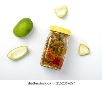 Mango Pickle Jar With Pieces Of Raw Green Mangoes On White Background
