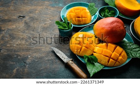 mango and mango slices on the board. On a rustic background. Side view. Copy space.