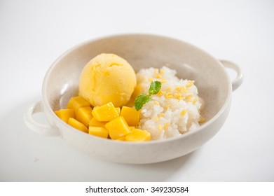 Mango with sticky rice and mango sherbet ice cream in ceramic bowl