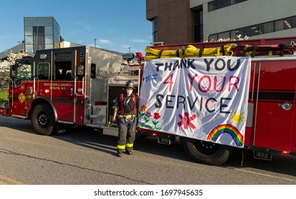 Manhasset, NY - April 7, 2020: Brett Auerbach poses at poster created by his kids as Nassau County first responders line up to salute heroes of COVID-19 pandemic at North Shore University Hospital