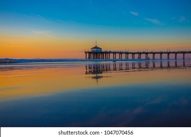 Manhattan Beach Pier During Sunset In Manhattan Beach, California, With The Mirror Reflection From The Sand