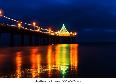 Manhattan Beach Pier with festive lights reflecting on the water. - Powered by Shutterstock