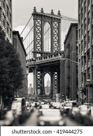 Manhattan Bridge and Empire State Building seen from Brooklyn, New York. Black and white image with a blurred foreground