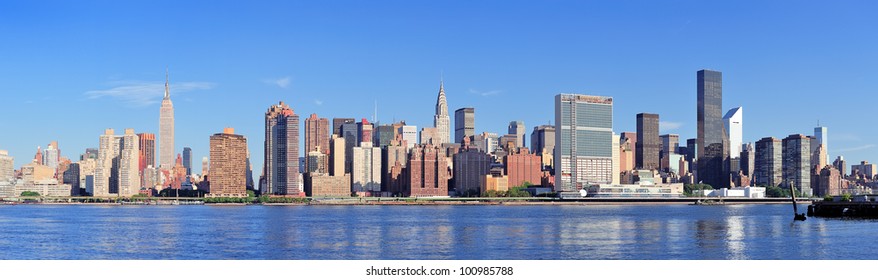 Manhattan Midtown Skyline Panorama Over East River With Urban Skyscrapers And Blue Sky In New York City