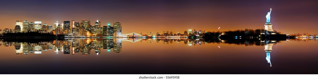 Manhattan, New York City Skyline With Statue Of Liberty At Night With Reflection