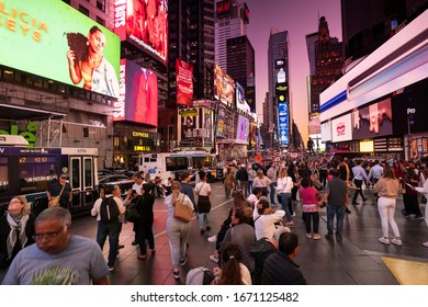 Manhattan, New York - September 18, 2019:  People Gather By The Digital Advertising And Brightly Lit Billboards At Night On Broadway In Times Square New York City USA