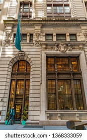 Manhattan, New York, USA - April 10, 2019: View Of The Building Tiffany Co. On Wall Street In The Financial District Of Manhattan With A Doorman And Two Clients Behind The Window.