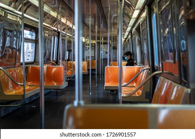 Manhattan, New York, USA - April 27, 2020.
Only two passengers in subway train during rush hour. Covid-19 pandemic in New York.