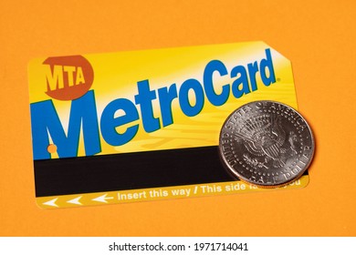 Manhattan, New York, USA - April 8. 2021: Metro Card With Half Dollar Coin On Orange Background. Concept Of Cost For Public Transport In NYC