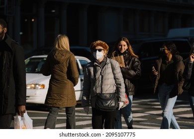 Manhattan, New York, USA - December 22, 2021: People Walking Across A Busy Intersection On Broadway With Face Masks On Due To COVID-19 Outbreak While Omicron Variant Spread.