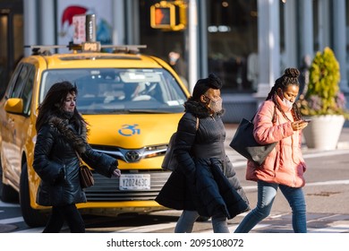 Manhattan, New York, USA - December 22, 2021: People Walking Across A Busy Intersection On Broadway With Face Masks On Due To COVID-19 Outbreak While Omicron Variant Spread.