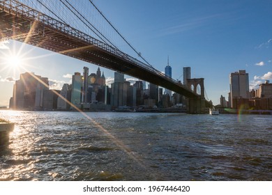 MANHATTAN, NYC - OCTOBER 06, 2019: Brooklyn Bridge, East River And Lower Manhattan In Background. NYC Skyline. Bright Sunny Day And Sunlight. Dumbo. Sightseeing Place Among Locals And Tourists In NYC.