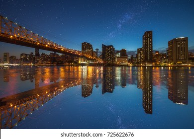Manhattan panorama at dusk as seen from Roosevelt Island in New York, USA. New York night scene with East River waterfront illuminated buildings and starry sky with milkyway. - Shutterstock ID 725622676