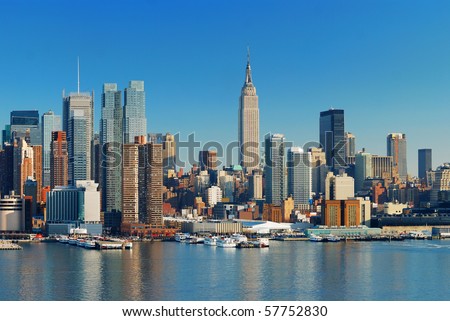 Manhattan Skyline with Empire State Building, New York City over Hudson River with boat and pier.