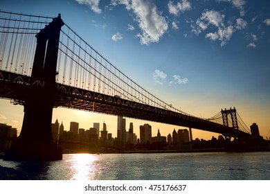 Manhattan skyline under Manhattan Bridge at sunset, New York