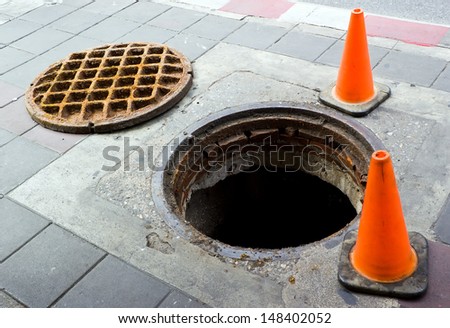 Manhole cover open on the foot bath near street