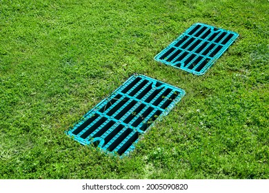 manhole drainage grates on the lawn with green grass septic tank cover, sump cesspool drainage system environment design side view with copy space, nobody.