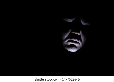 Maniac Face Silhouette Illuminated By Torch On Black Background. Dark Background. Horror Background. Black Background. Halloween Horror Concept.