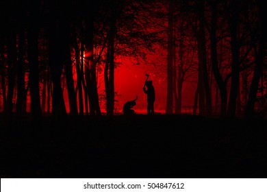 Maniac swings ax on his prey. Murder in the park. Maniac kills his victim in the night deserted park. Silhouettes in night foggy forest